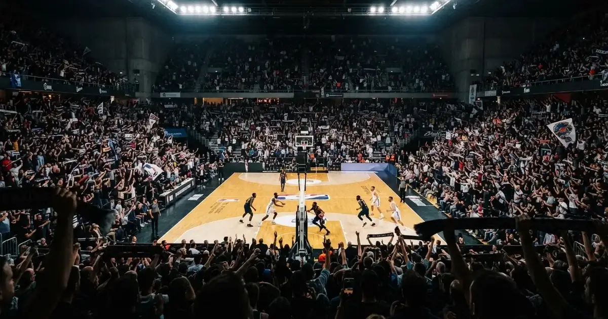Een volle sporthal onder schijnwerpers, van grote afstand gefotografeerd
